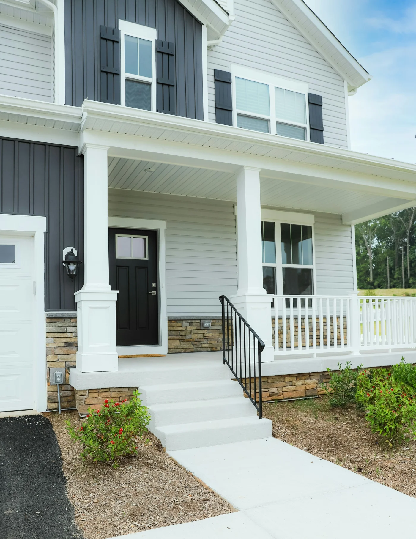 Craftsman-style home with white siding, roof gutters, and a welcoming front porch